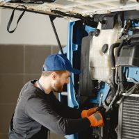 Man with tools for truck. Worker in uniform. Faulty truck